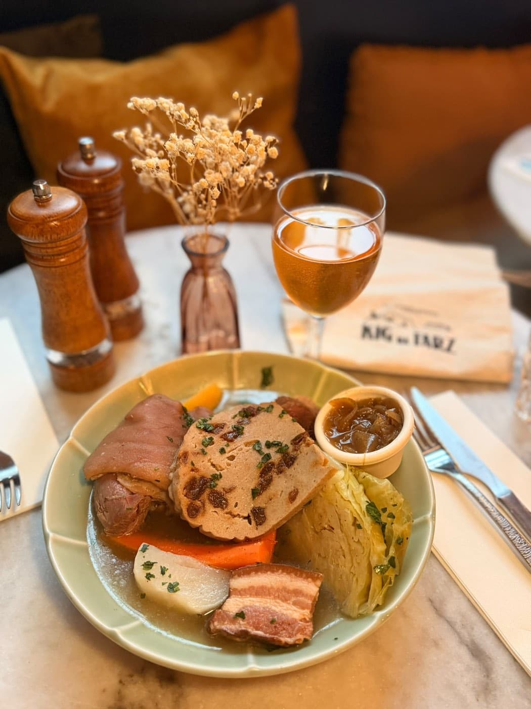 Assiette de kig ha farz chez Ty Louis : viandes du pot-au-feu breton, tranche de farz de blé noir aux raisins, chou, carotte, navet et sauce lipig en ramequin, avec un verre de cidre