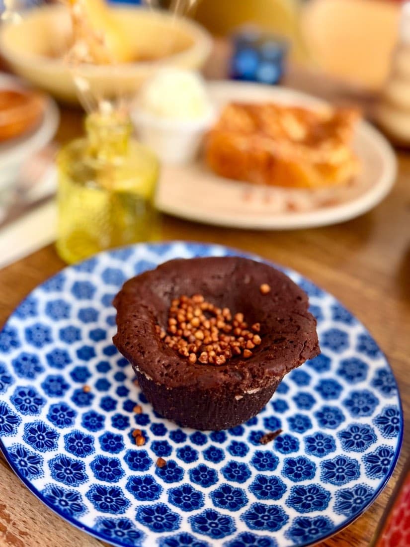 Fondant au chocolat parsemé de sarrasin torréfié sur une assiette à motif breton, au brunch de Ty Louis