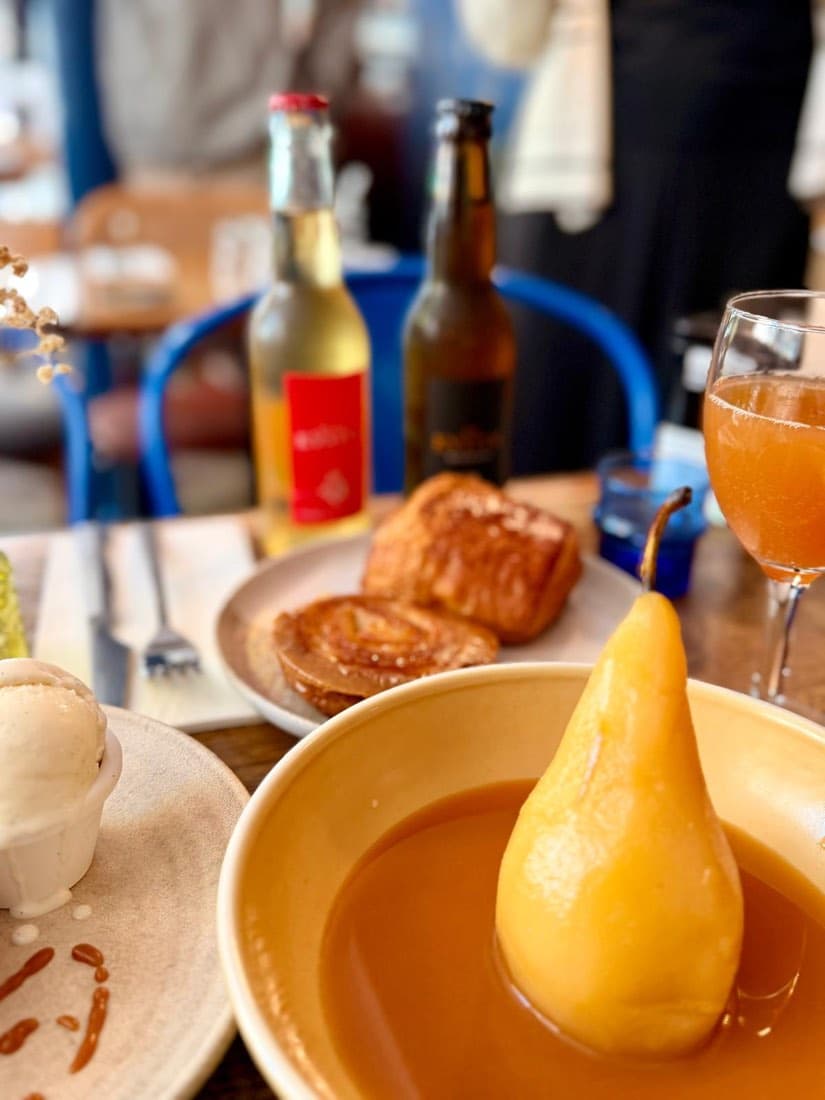 Poire pochée nappée de caramel dans une assiette creuse, au brunch de Ty Louis