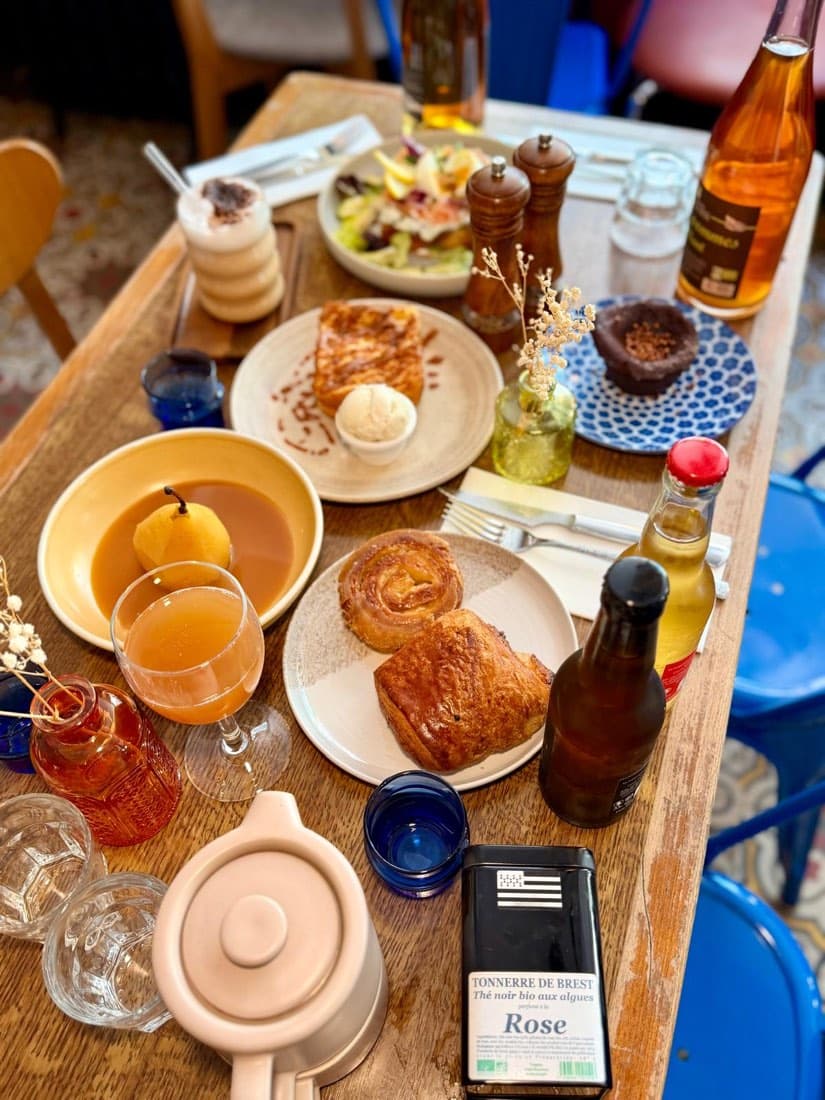 Une table de brunch dressée chez Ty Louis : pain perdu, poire pochée, viennoiserie, latte et thé breton