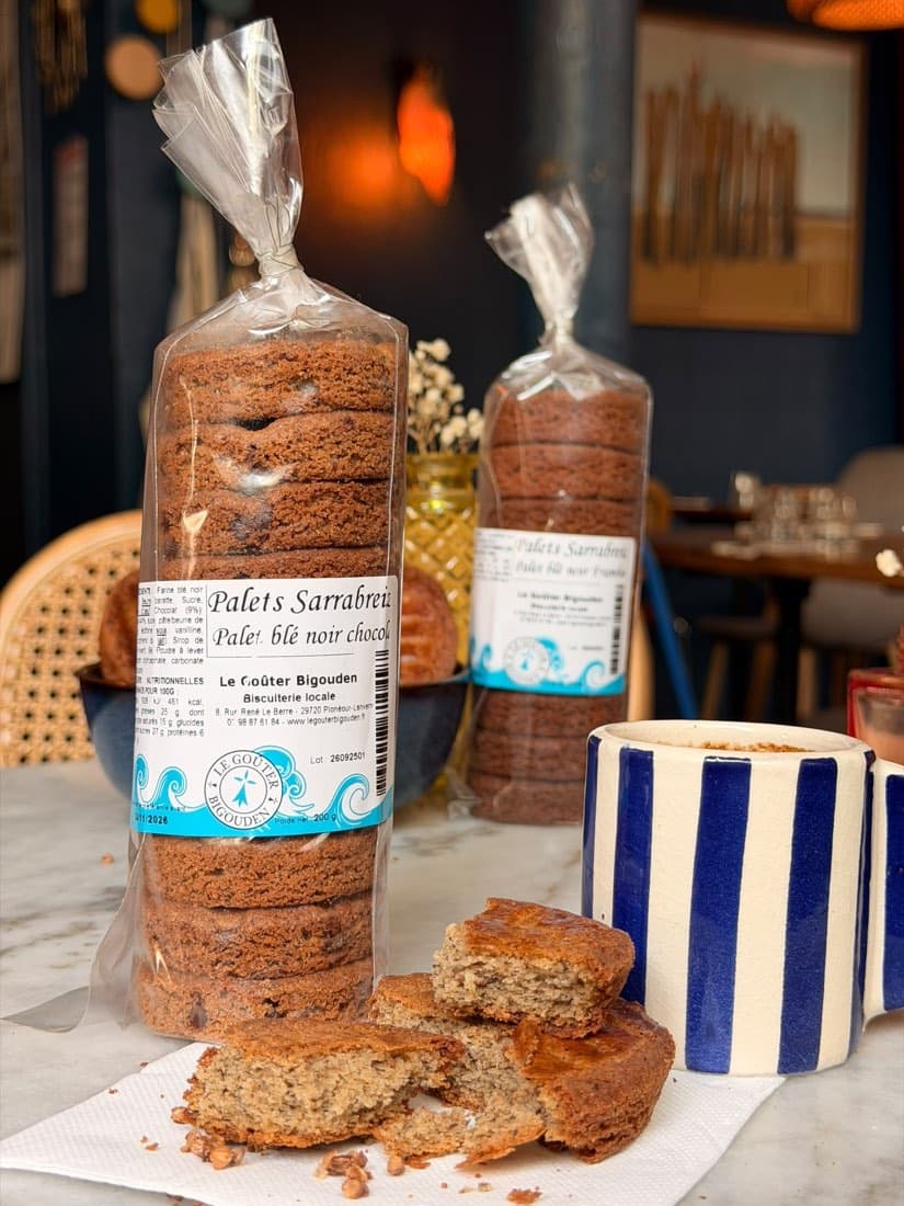 Un sachet de palets Sarrabreizh au blé noir et au chocolat à côté d’un café chez Ty Louis