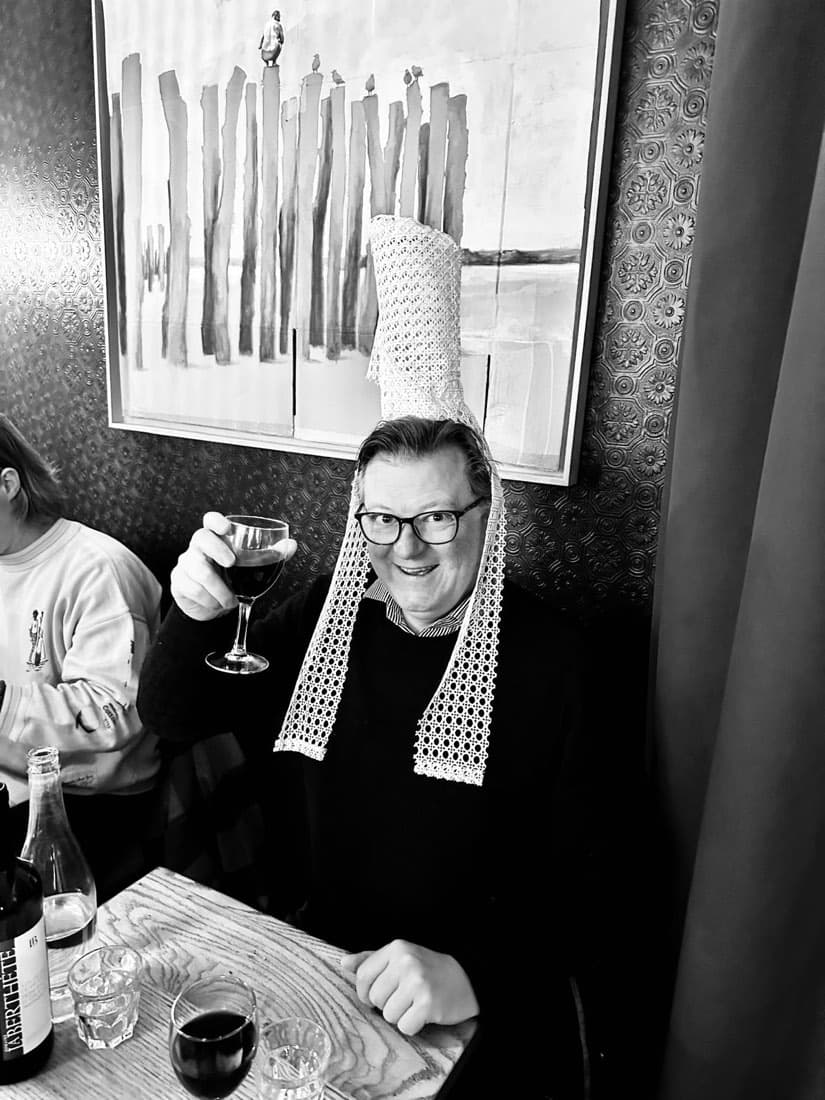 Un convive coiffé de la bigoudène lève son verre pour la galette des rois chez Ty Louis