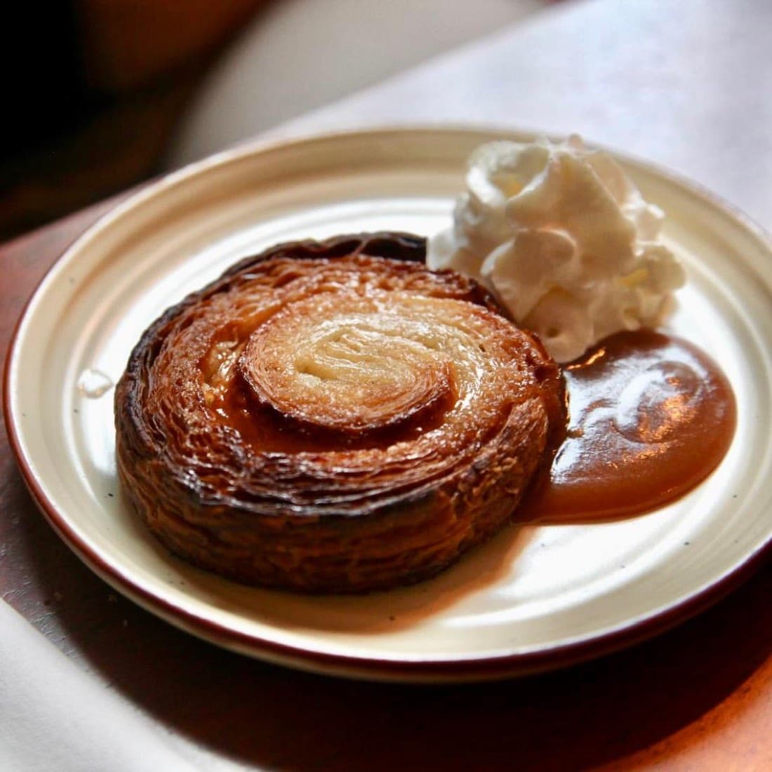 Un kouign-amann individuel caramélisé servi avec chantilly et caramel au beurre salé, chez Ty Louis