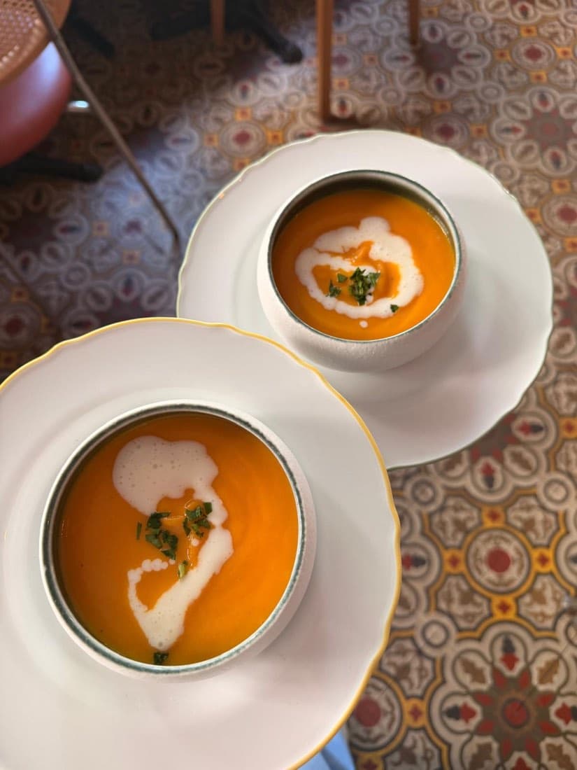 Deux bols de velouté de potimarron avec une écume et des herbes fraîches, chez Ty Louis