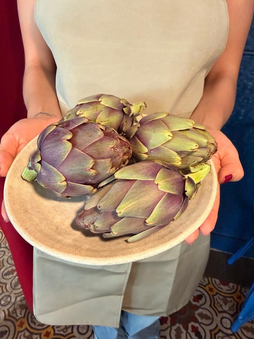 Quatre artichauts violets de Bretagne présentés sur une assiette en grès chez Ty Louis